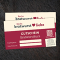 Gutschein Bratwurstkurse liegt auf schwarzen Untergrund