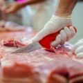 Stück Fleisch wird in einer Metzgerei geschnitten